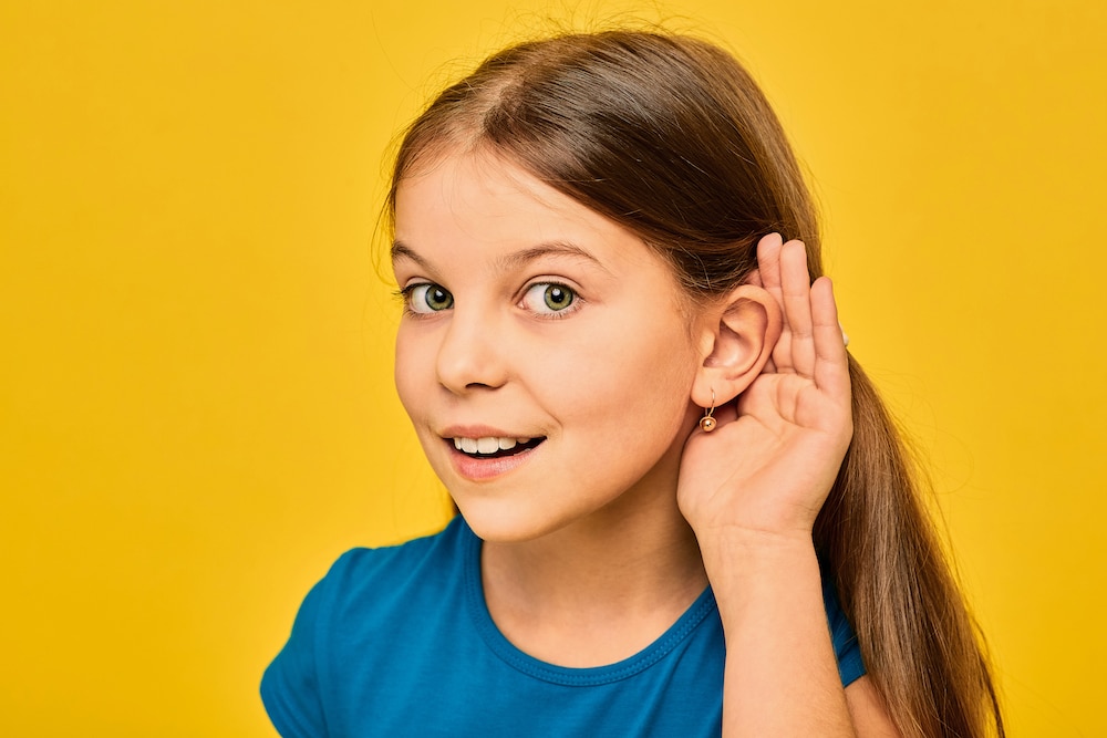 Top Earwax Dos and Don'ts young girl holding hand to ear
