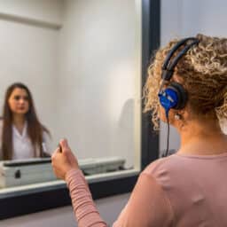 A woman gets an audiology exam.