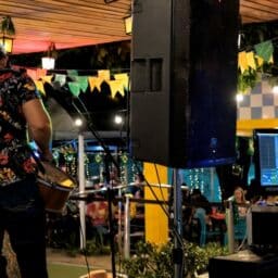 A musician playing guitar at a live music event -- shot from behind