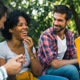 Group of friends talking to each other, one friend is wearing a hearing aid