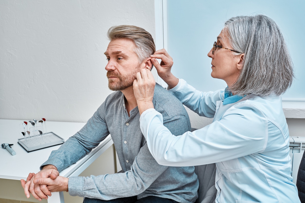 Doctor adjusts hearing aid