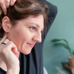 Woman touches her hearing aid