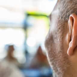 man wearing hearing aid in office setting