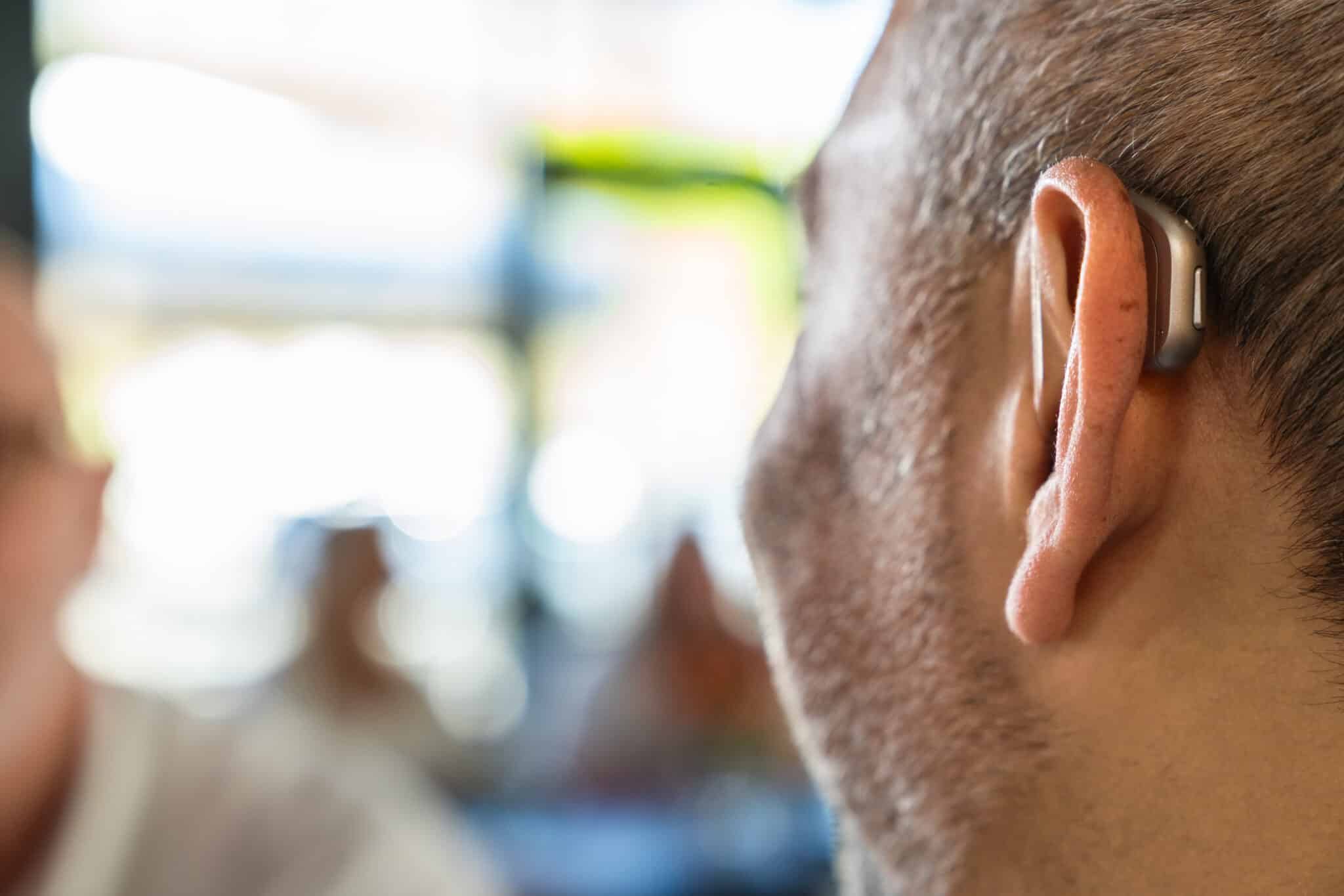 man wearing hearing aid in office setting