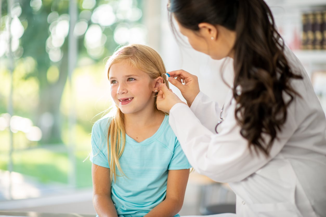 Fitting a Hearing Aid on a young girl.