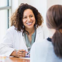 Friendly, professional doctor smiling and listening to her patient