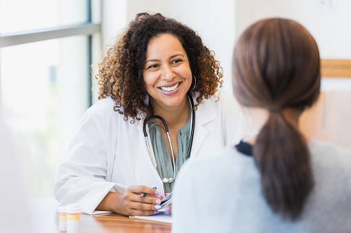 Friendly, professional doctor smiling and listening to her patient